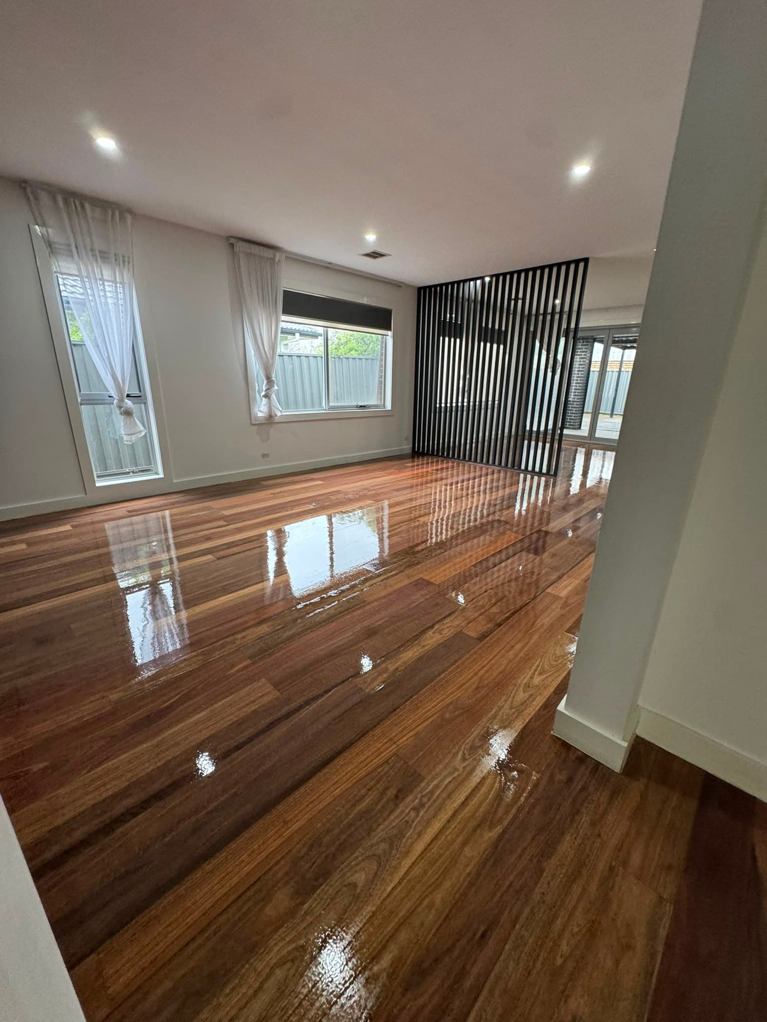 Deep brown timber floor polished to a mirror-like high-gloss finish