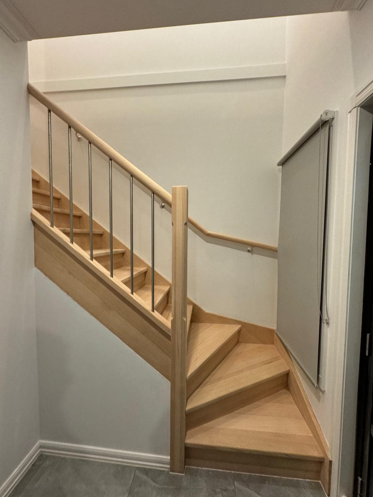 Light timber staircase with matching handrail and steel balusters